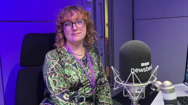 Woman seated in a radio studio