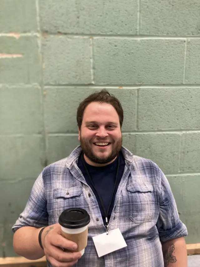 Green Party candidate for Salisbury Barney Norris holding a cup of coffee and smiling