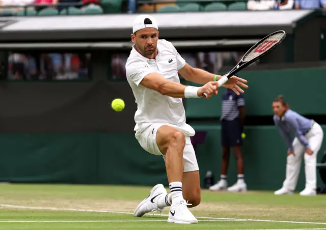 Grigor Dimitrov slides to hit a backhand shot