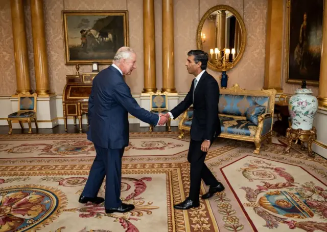 King Charles II shaking hands with Rishi Sunak inside Downing Street