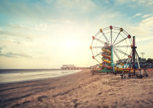 Big wheel on Cleethorpes beach with pier in background