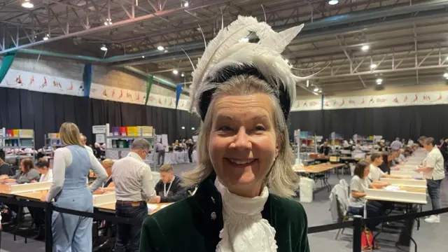 Amy Crawfurd wearing a large hat made up of feathers at a count