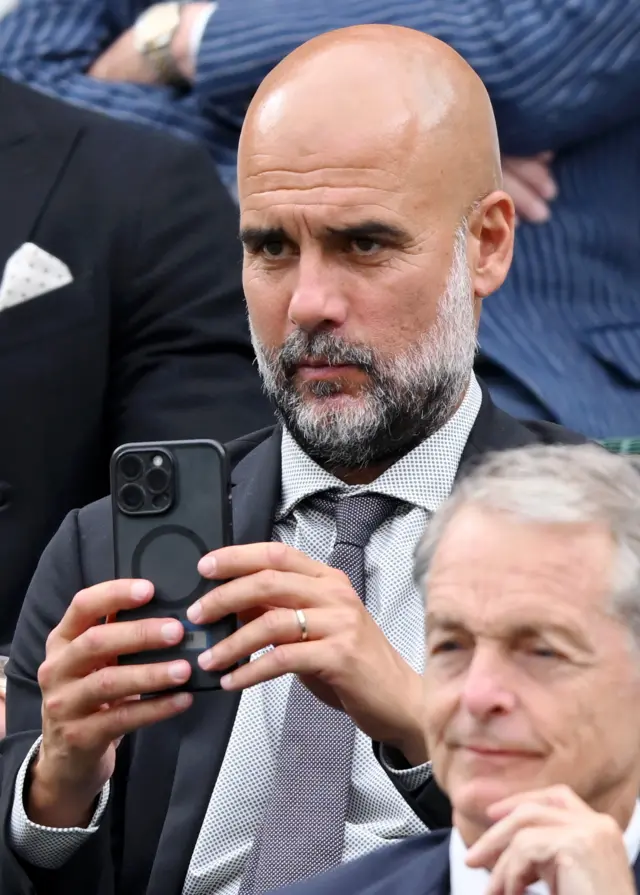 Pep Guardiola takes a photo