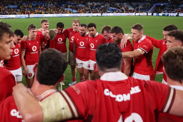 Wales players huddle at the end of the game