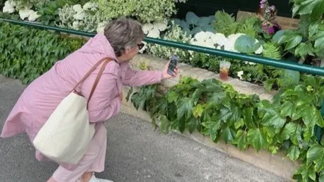 A woman taking a photo of her Pimms cup