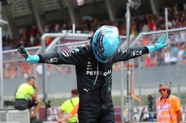 George Russell does his arms out intro pose after winning in Austria