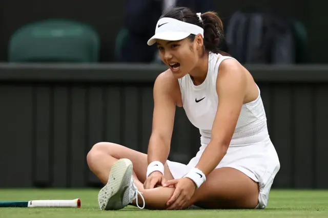 Emma Raducanu holds her knee