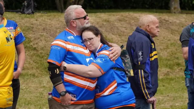 People embrace on the cortege route