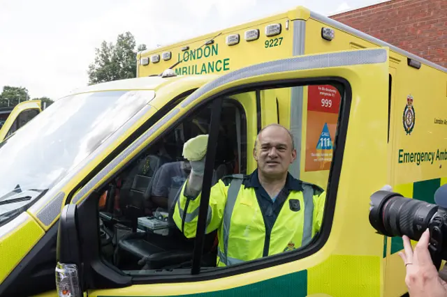 Liberal Democrats leader Sir Ed Davey cleans the window of an ambulance during his visit to Wimbledon Ambulance Station as part of general election campaign in London,