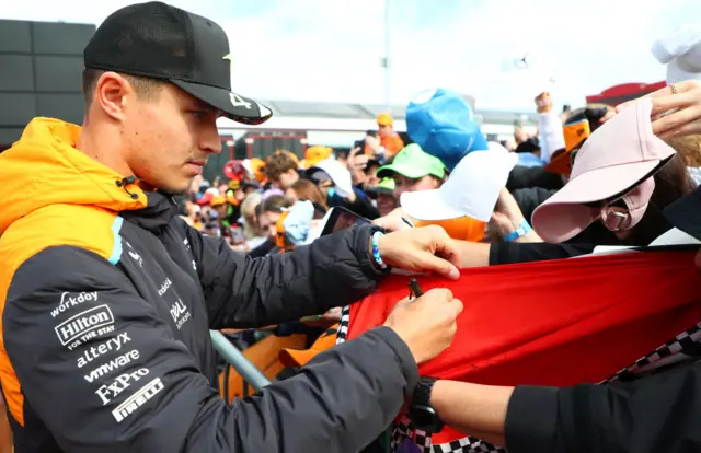 Lando Norris signs autographs