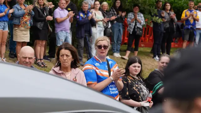 Applause and tears as the cortege passes by