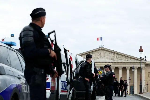 Police officers stand in front of the building of French National Assembly (Assemblee Nationale) before the first results of the second round of France's legislative election in Paris on July 7, 2024. F