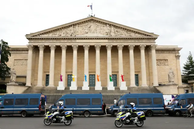 Police officers stand in front of the building of French National Assembly (Assemblee Nationale) before the first results of the second round of France's legislative election in Paris on July 7, 2024. F