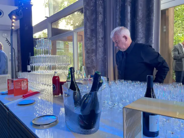 Barman with a lot of empty champagne glasses
