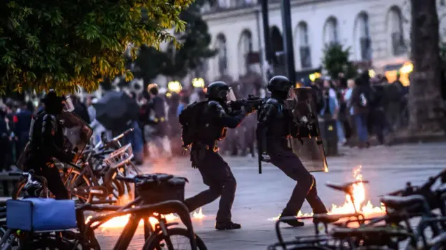 Riot police next to a Molotov cocktail
