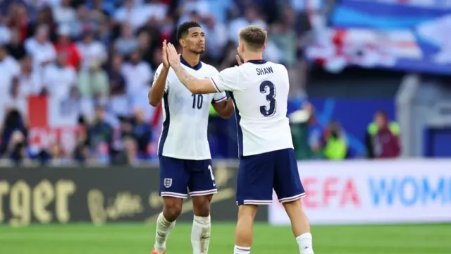 Jude Bellingham of England celebrates with teammate Luke Shaw after scoring a penalty kick during the UEFA EURO 2024 quarter-final match between England and Switzerland at Düsseldorf Arena on July 06, 2024 in Dusseldorf, Germany.