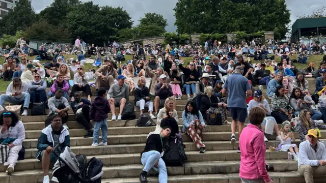 Lots of people sitting on a hill