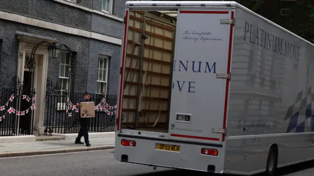 Atruck is waiting for all the furniture to be loaded in front of Downing St 10