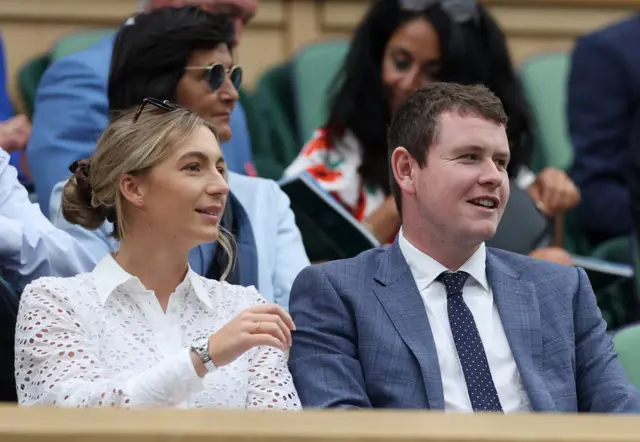 Golfer Robert MacIntyre and his partner Shannon Hartley are seen on the royal box