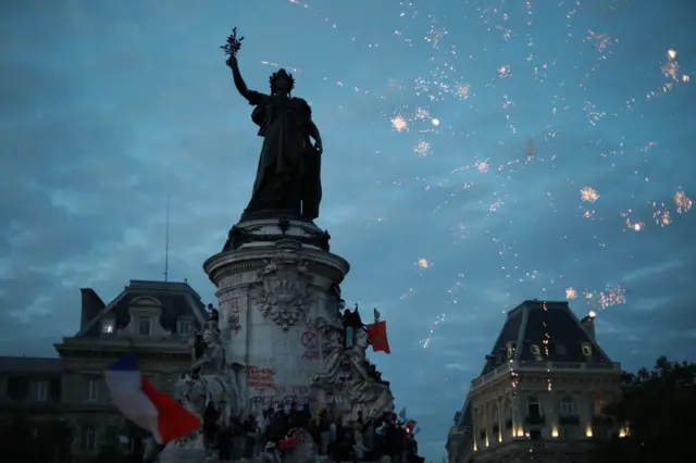 Fireworks explode over the statue of Marianne