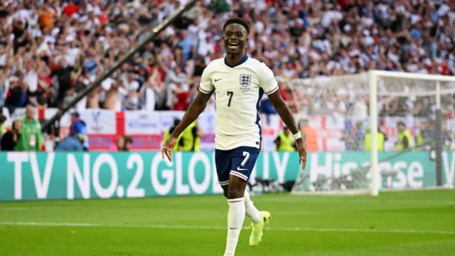 Bukayo Saka of England celebrates scoring his team's first goal during the UEFA EURO 2024 quarter-final match between England and Switzerland at Düsseldorf Arena on July 06, 2024 in Dusseldorf, Germany