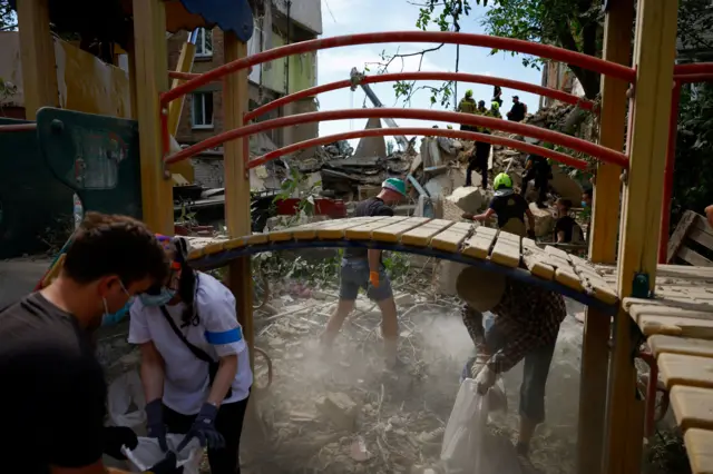 People removing debris at the site of a building which was hit by the strike.