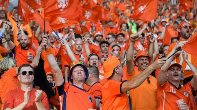 the fans of the Netherlands wave their flags during the UEFA EURO 2024 quarter-final match between Netherlands and Türkiye at Olympiastadion on July 06, 2024 in Berlin, Germany.