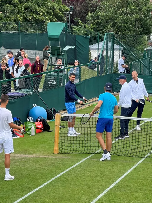 Tennis player Novak Djokovic warming up on a tennis court