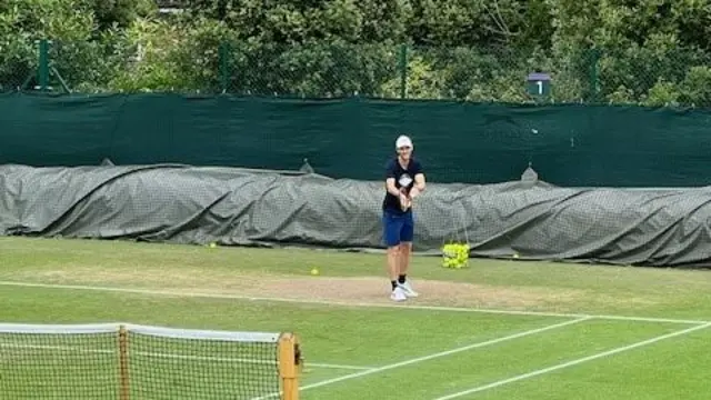 Man practising tennis on a tennis court