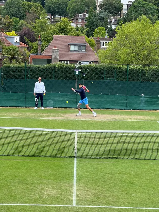 Tennis player Novak Djokovic practising with a tennis racquet