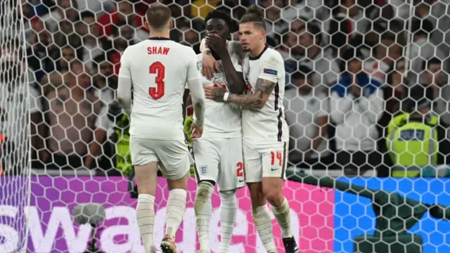 Bukayo Saka of England is consoled by Luke Shaw and Kalvin Phillips after missing their side's fifth penalty in the penalty shoot out during the UEFA Euro 2020 Championship Final between Italy and England at Wembley Stadium on July 11, 2021 in London, England.