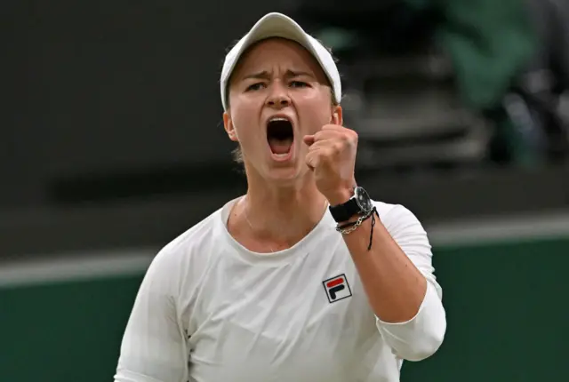 Barbora Krejcikova holds up her fist and cheers in celebration