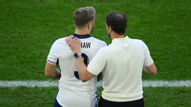 Gareth Southgate, Head Coach of England, speaks with Luke Shaw of England as he prepares to be substituted on during the UEFA EURO 2024 quarter-final match between England and Switzerland at Düsseldorf Arena on July 06, 2024 in Dusseldorf, Germany.