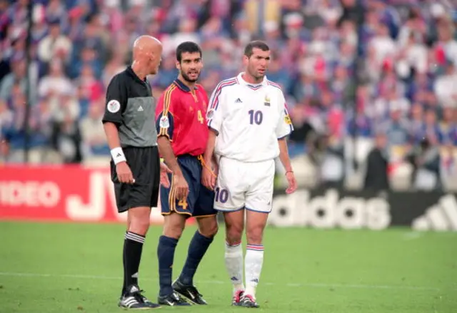 Zinedine Zidane (No.10 Shirt) of France and Josep Guardiola (No.4 Shirt) of Spain talk to Referee Pierluigi Collina