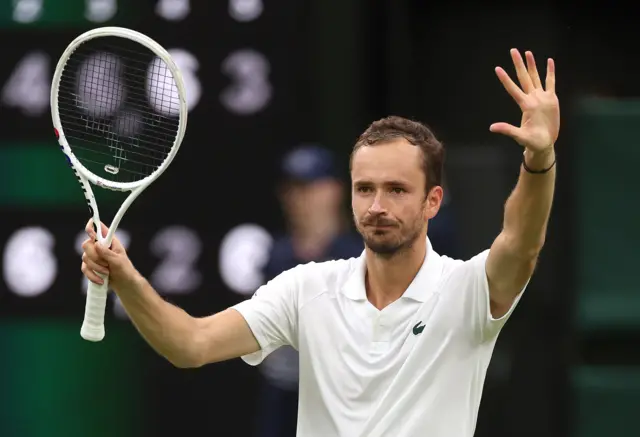 Daniil Medvedev raises his hand and racquet to crowd in celebration