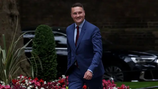 Wes Streeting arriving at Downing Street, he is in front of some flowers