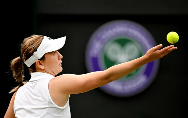 Lulu Sun tosses the ball to serve