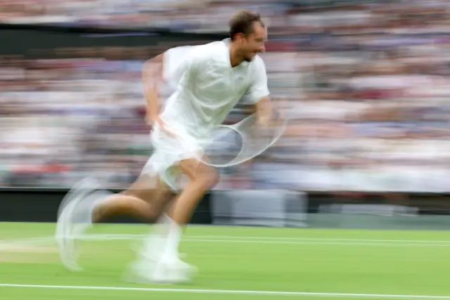 Daniil Medvedev sprints on court in a blurred image