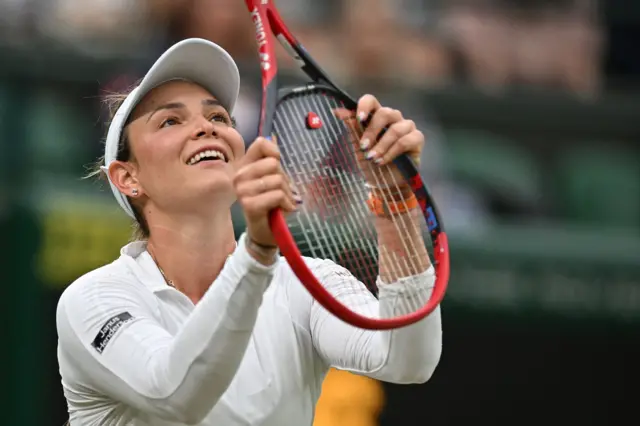 Donna Vekic holds the racquet upside down and laughs in reaction to a point