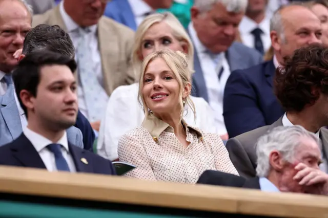 Actor Sienna Miller smiles in the Royal Box on Centre Court