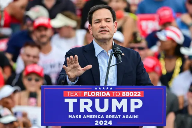 Marco Rubio on a stage, gesturing to the crowd