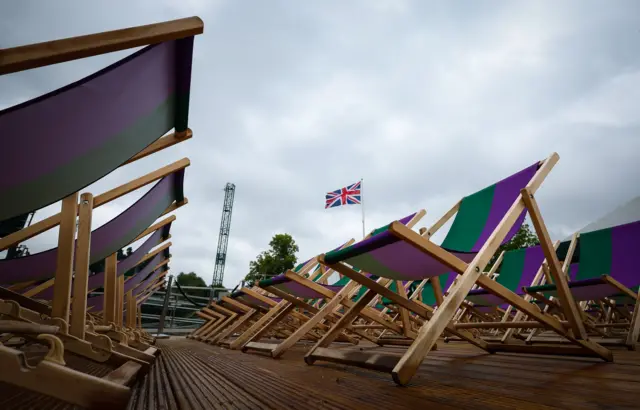 Deck chairs laid out on the Wimbledon grounds with a Union Jack flag flying high on mast in the background