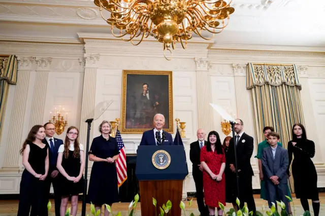 President Joe Biden stands at the White House with family members of released prisoners