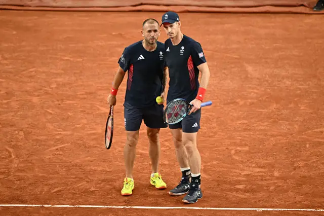 Andy Murray (R) speaks with Britain's Daniel Evans (