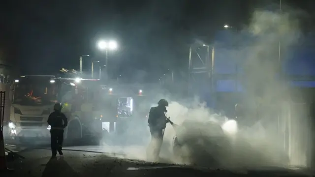 Firefighters extinguish a car fire on the streets in Hartlepool