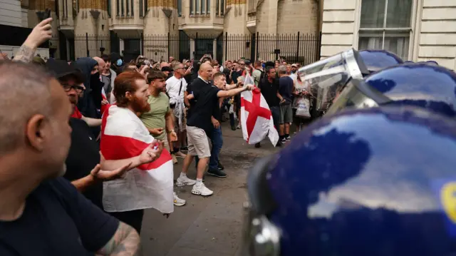 Protesters stand before a police line in central London