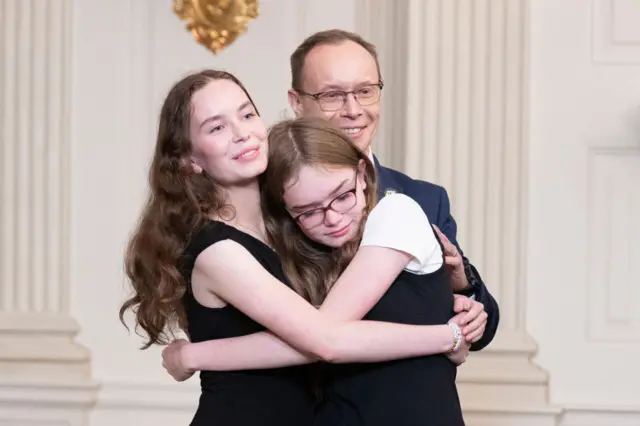 Miriam, Bibi and Pavel Butorin embrace at the White House