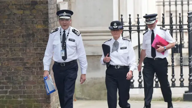 Police officers walk up Downing Street to attend a meeting with the prime minister