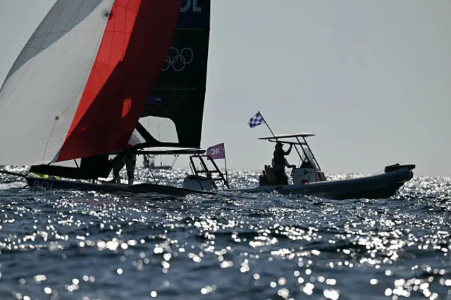 A staff waves a flag to interrupt the medal race