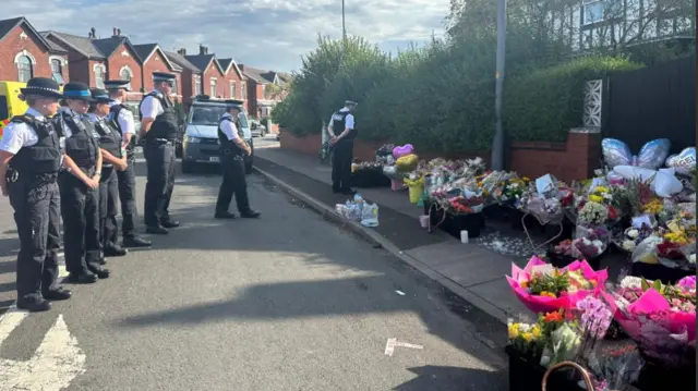 Police community support officers lay flowers in Southport